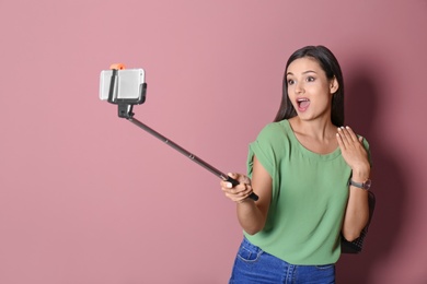 Photo of Young beautiful woman taking selfie against color background