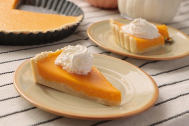 Photo of Fresh homemade pumpkin pie with whipped cream on table