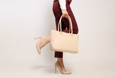 Young woman with stylish bag on white background, closeup