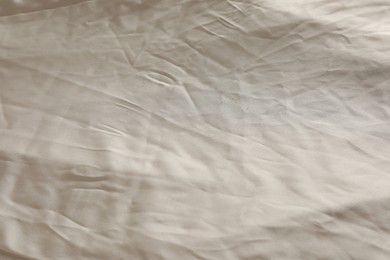 Photo of Crumpled dark beige fabric as background, closeup view