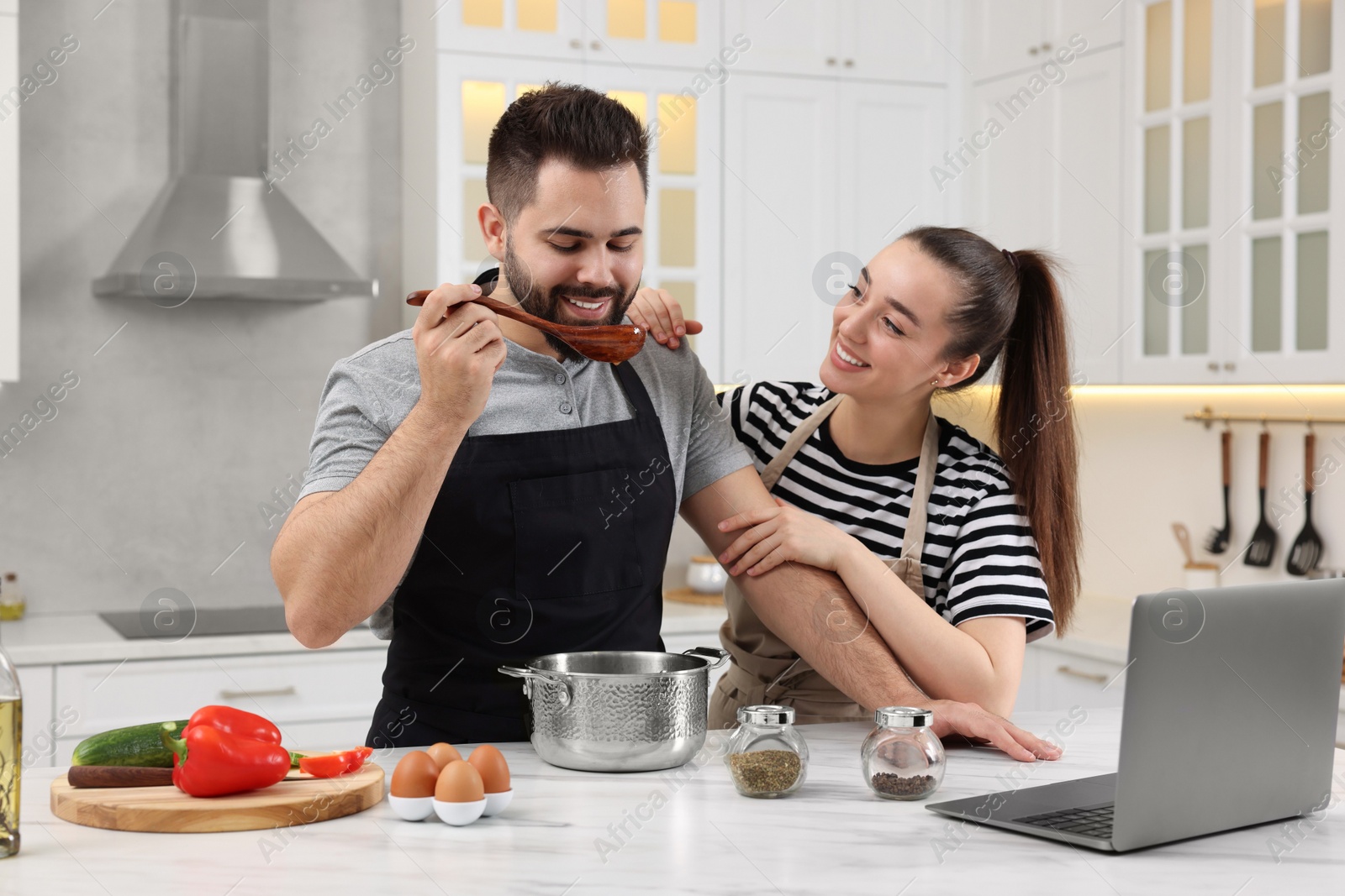 Photo of Lovely young couple cooking together in kitchen