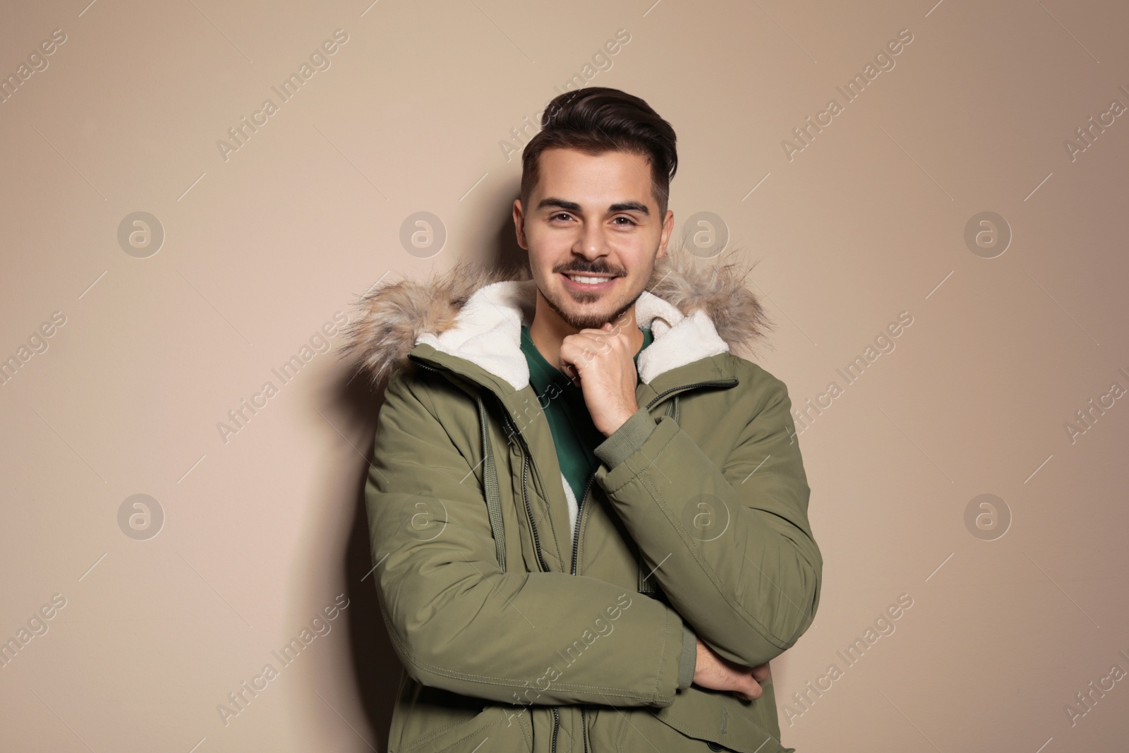 Photo of Young man wearing warm clothes on color background. Ready for winter vacation