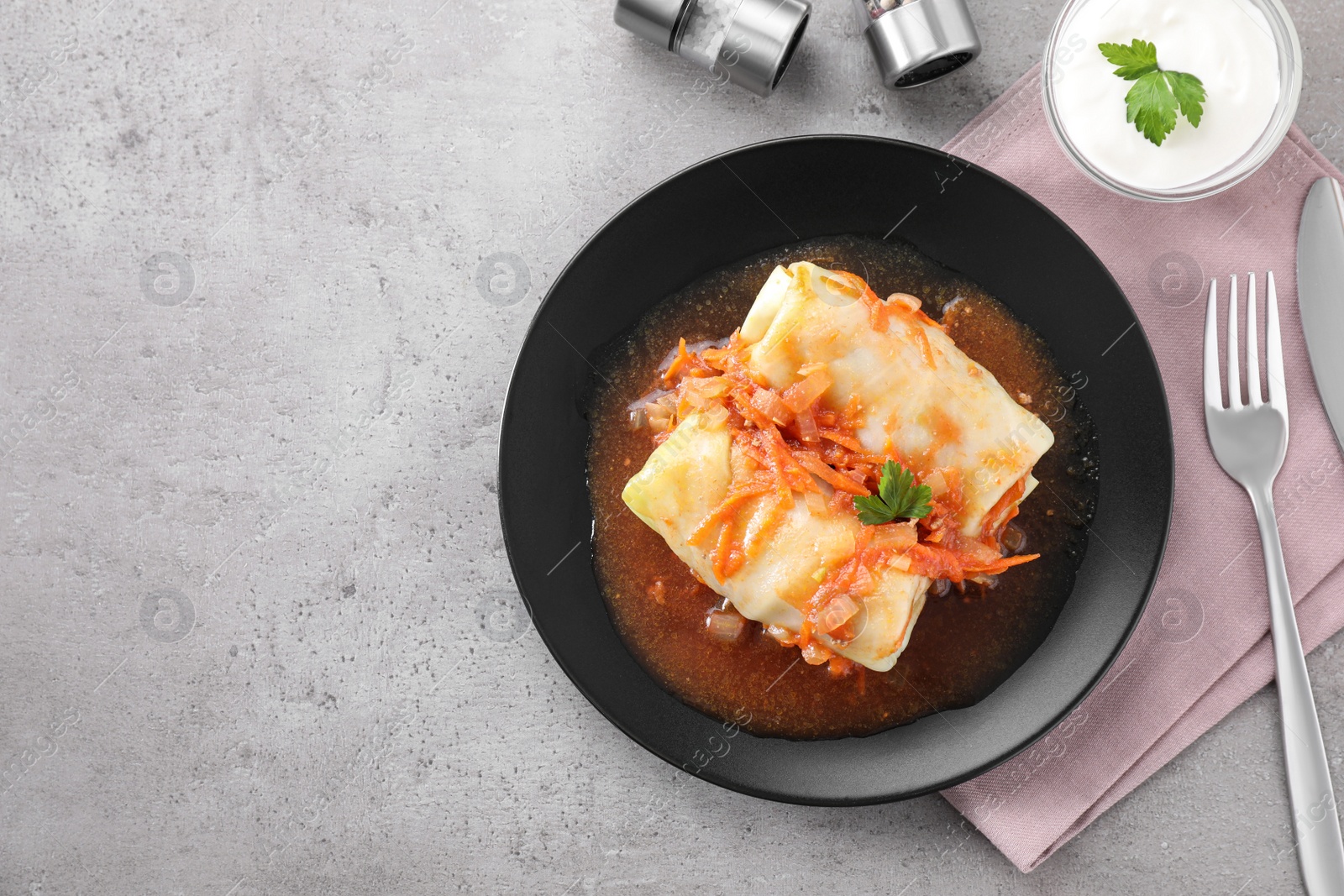 Photo of Delicious cabbage rolls served on grey table, flat lay