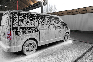 Modern automobile covered with foam at car wash