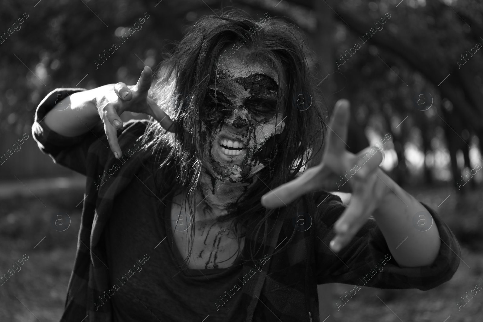 Photo of Scary zombie outdoors, black and white effect. Halloween monster