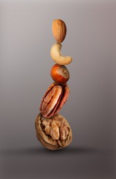 Image of Stacked different nuts on light brownish grey gradient background