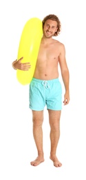 Photo of Attractive young man in swimwear with yellow inflatable ring on white background