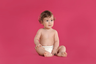 Photo of Cute little baby in diaper on pink background