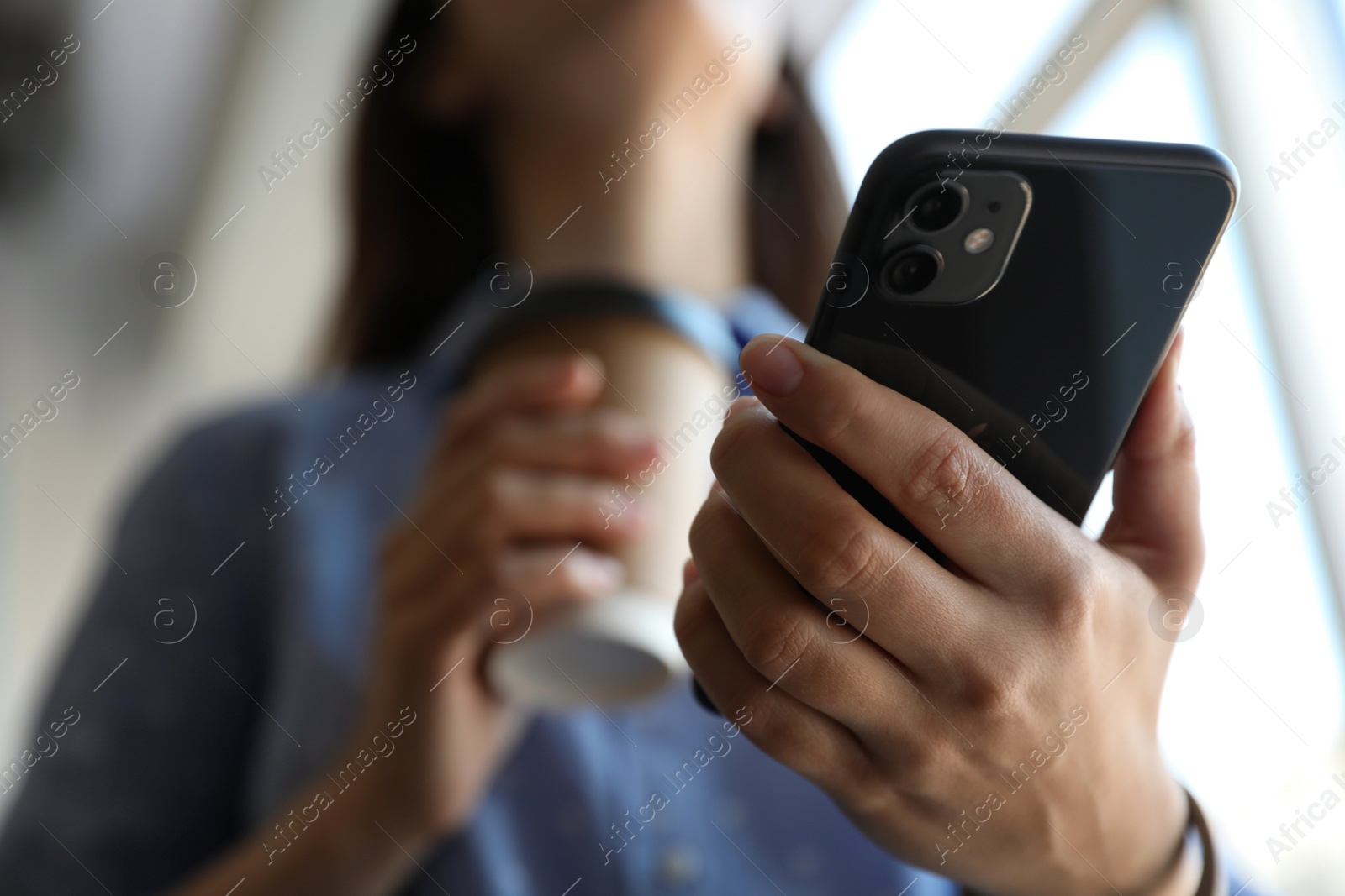 Photo of MYKOLAIV, UKRAINE - MARCH 16, 2020: Woman holding iPhone 11 Black indoors, closeup