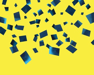 Shiny blue confetti falling on yellow background