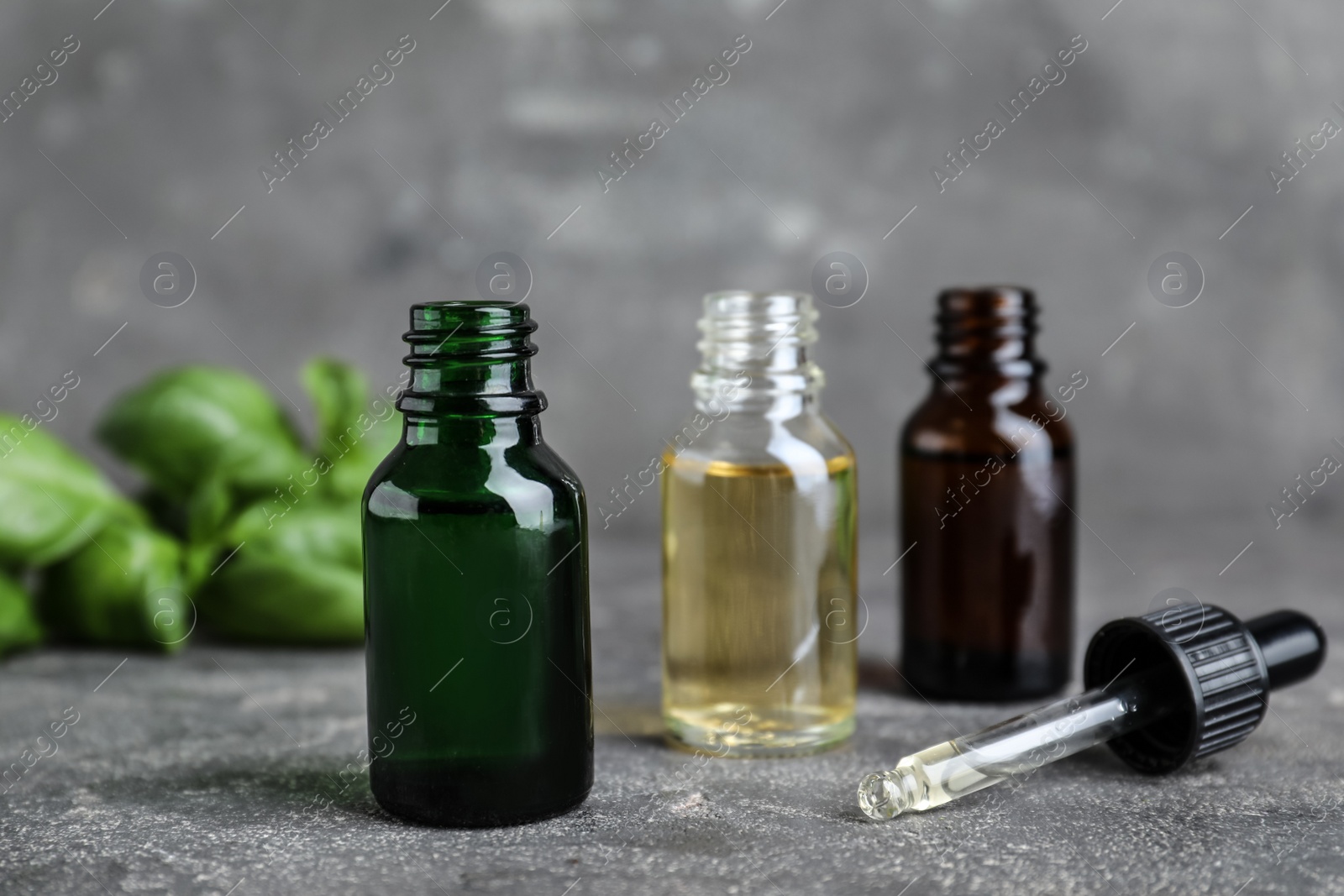 Photo of Different bottles with essential oils and dropper on table