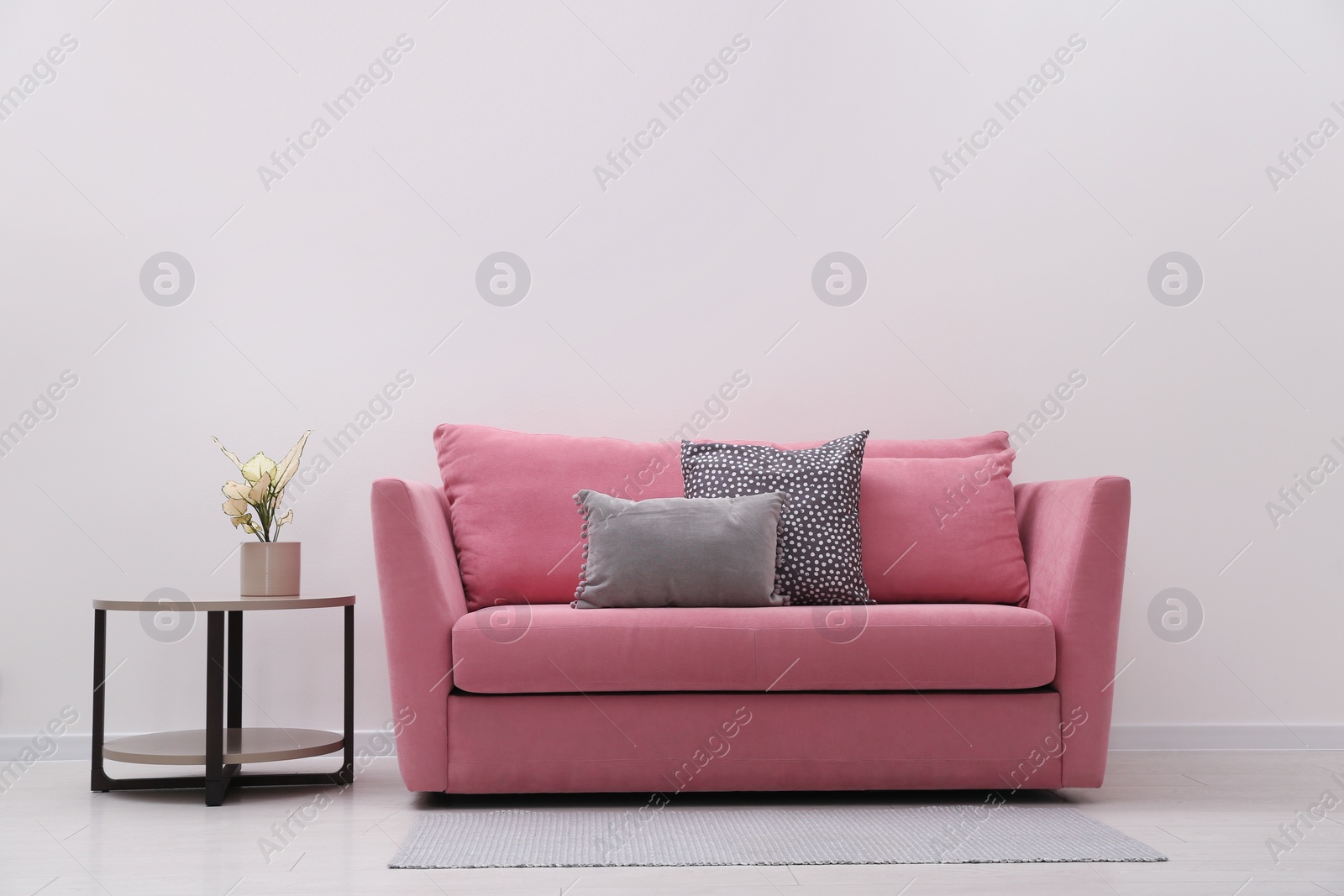 Photo of Simple room interior with comfortable pink sofa, space for text