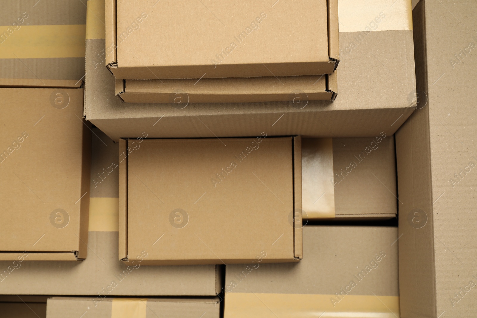 Photo of Many cardboard boxes as background, top view. Packaging goods