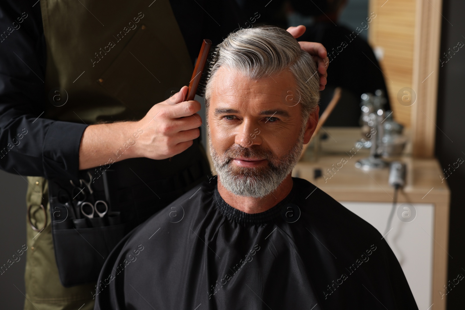 Photo of Hair styling. Professional hairdresser working with client in barbershop, closeup