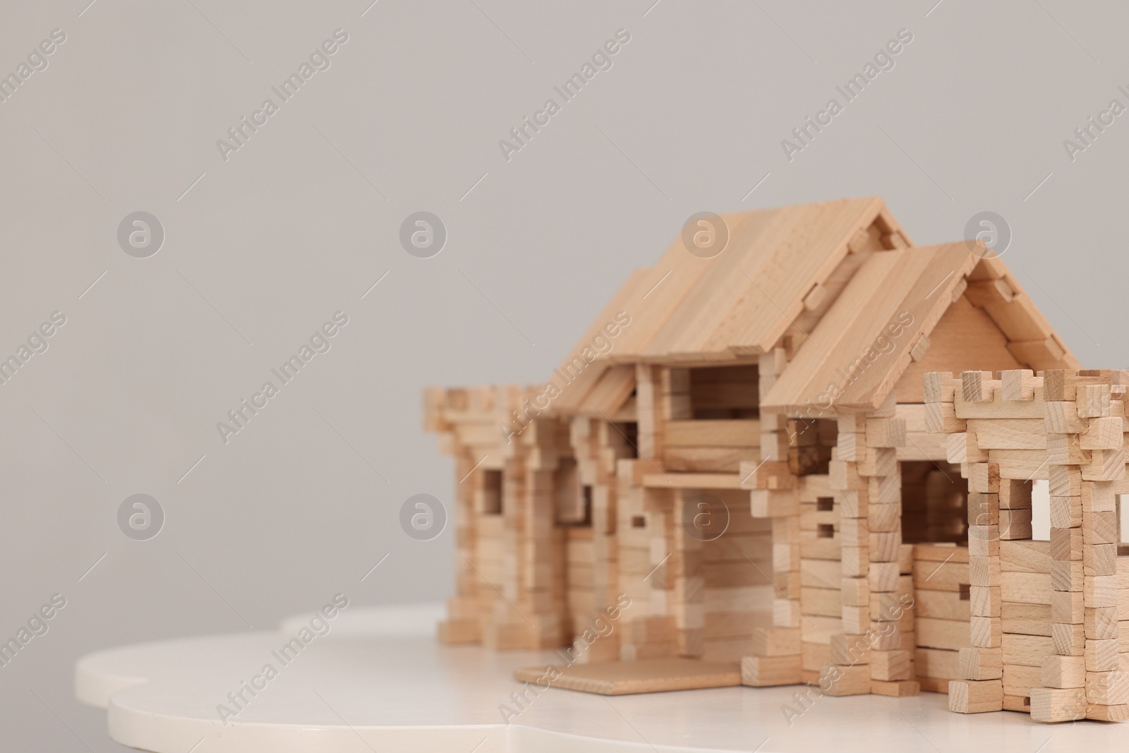 Photo of Wooden entry gate on table against light background, space for text. Children's toy