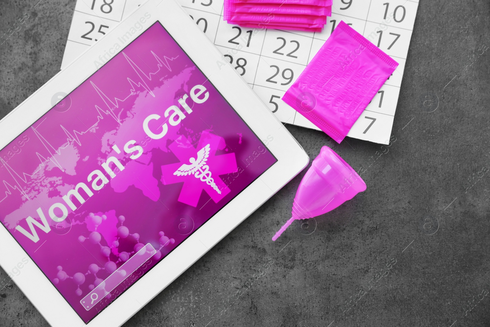 Photo of Flat lay composition with tablet, calendar and feminine hygiene items on grey background. Gynecological care