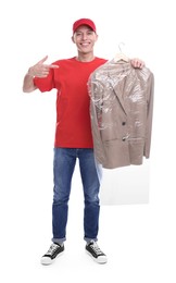 Photo of Dry-cleaning delivery. Happy courier holding jacket in plastic bag on white background