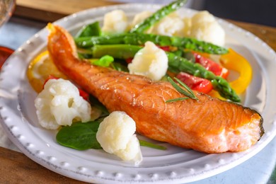 Photo of Healthy meal. Piece of tasty grilled salmon with vegetables on tray, closeup