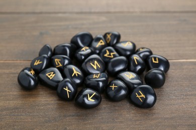 Pile of black rune stones on wooden table