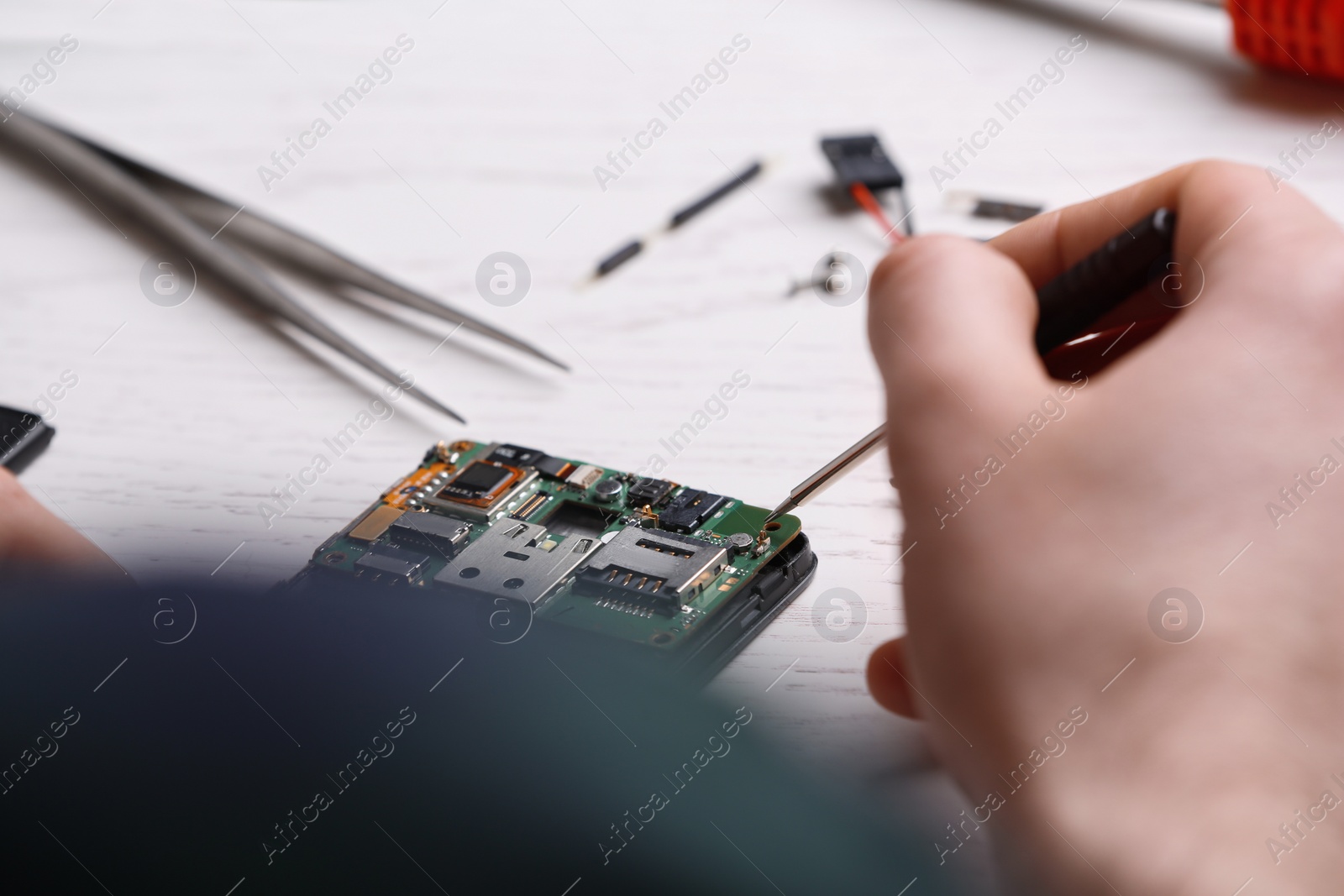 Photo of Technician fixing mobile phone at table, closeup. Device repair service