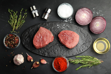 Flat lay composition with fresh beef cut on black table