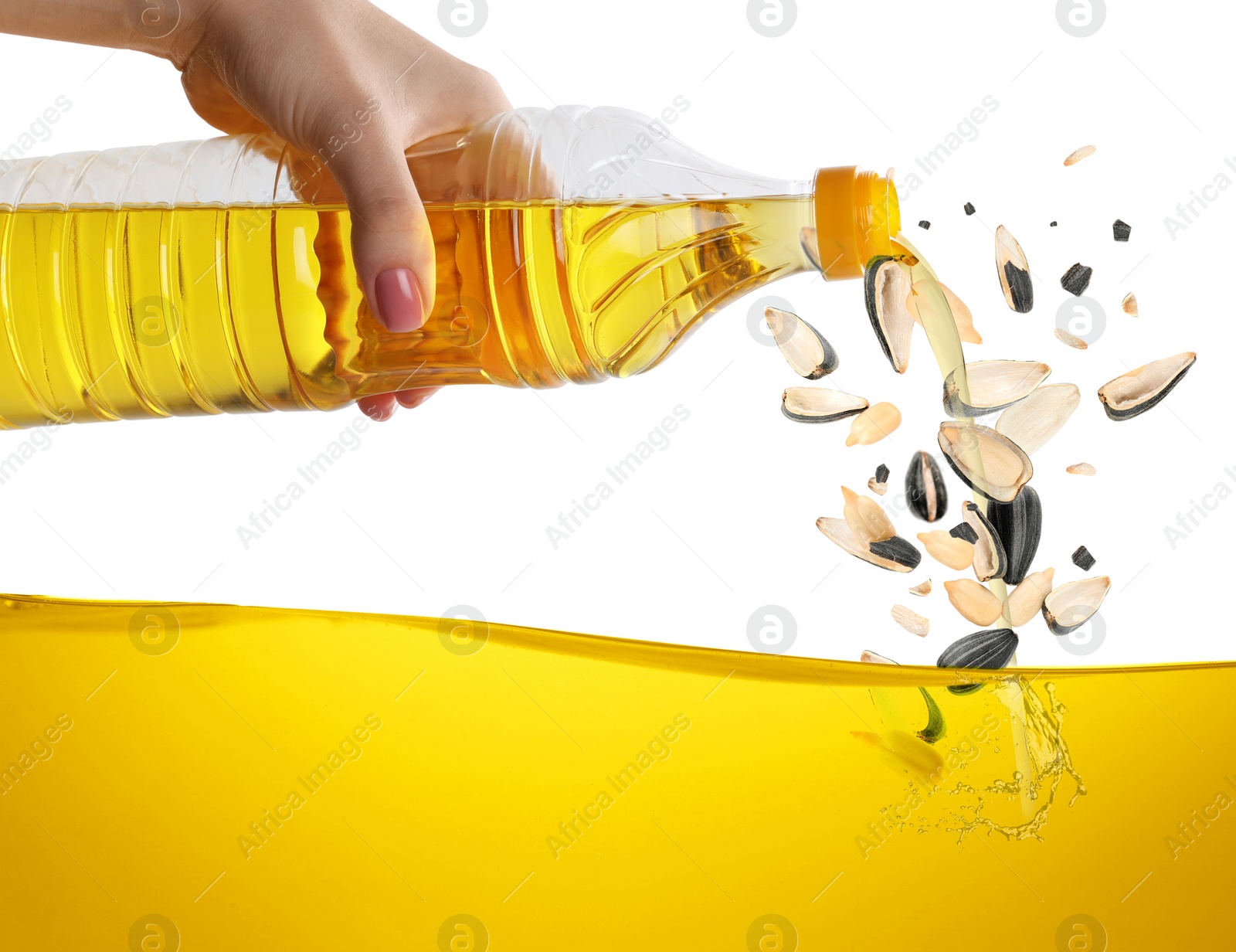 Image of Woman pouring sunflower oil on white background. Seeds falling into cooking oil