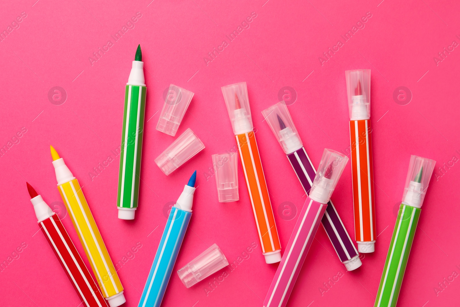 Photo of Many bright markers on pink background, flat lay