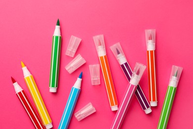 Many bright markers on pink background, flat lay