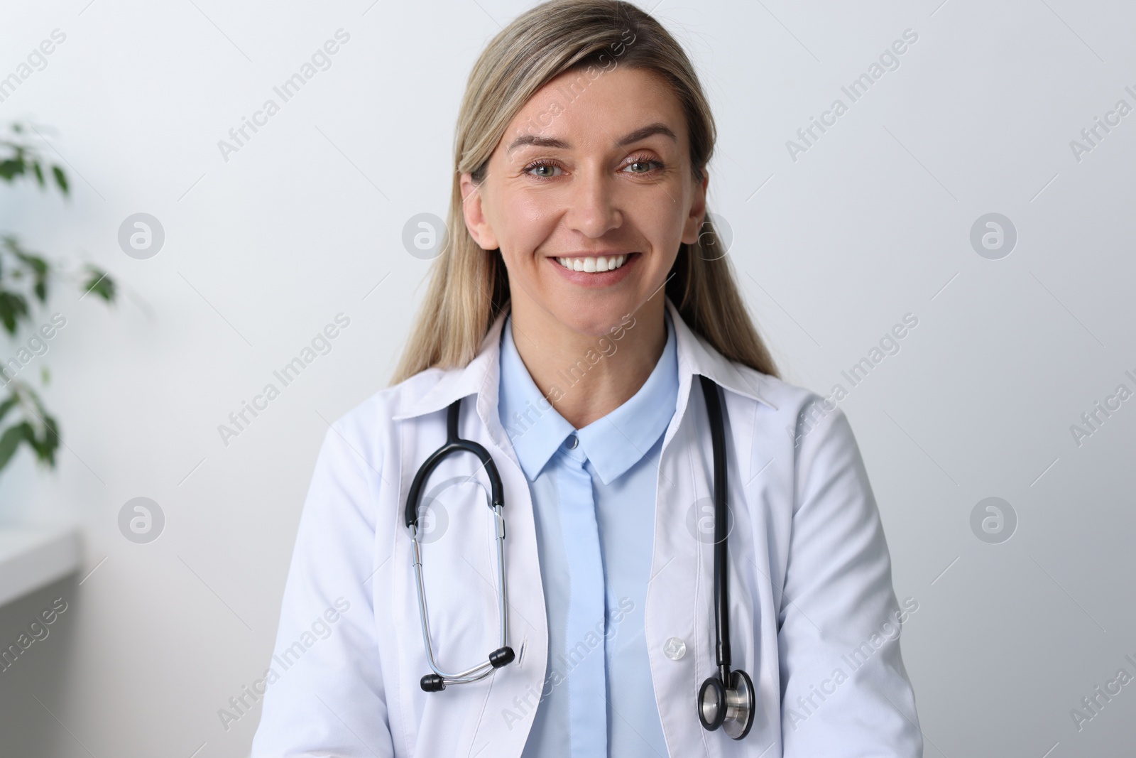 Photo of Portrait of happy doctor with stethoscope in hospital