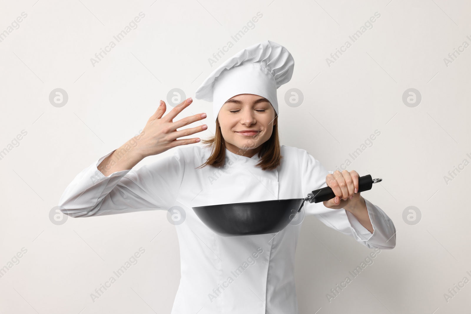 Photo of Professional chef with frying pan on light background