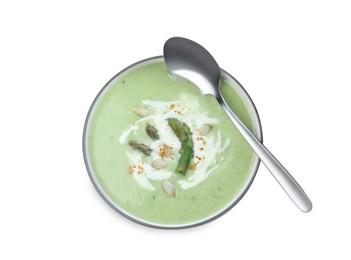 Photo of Delicious asparagus soup with pumpkin seeds and spoon on white background, top view