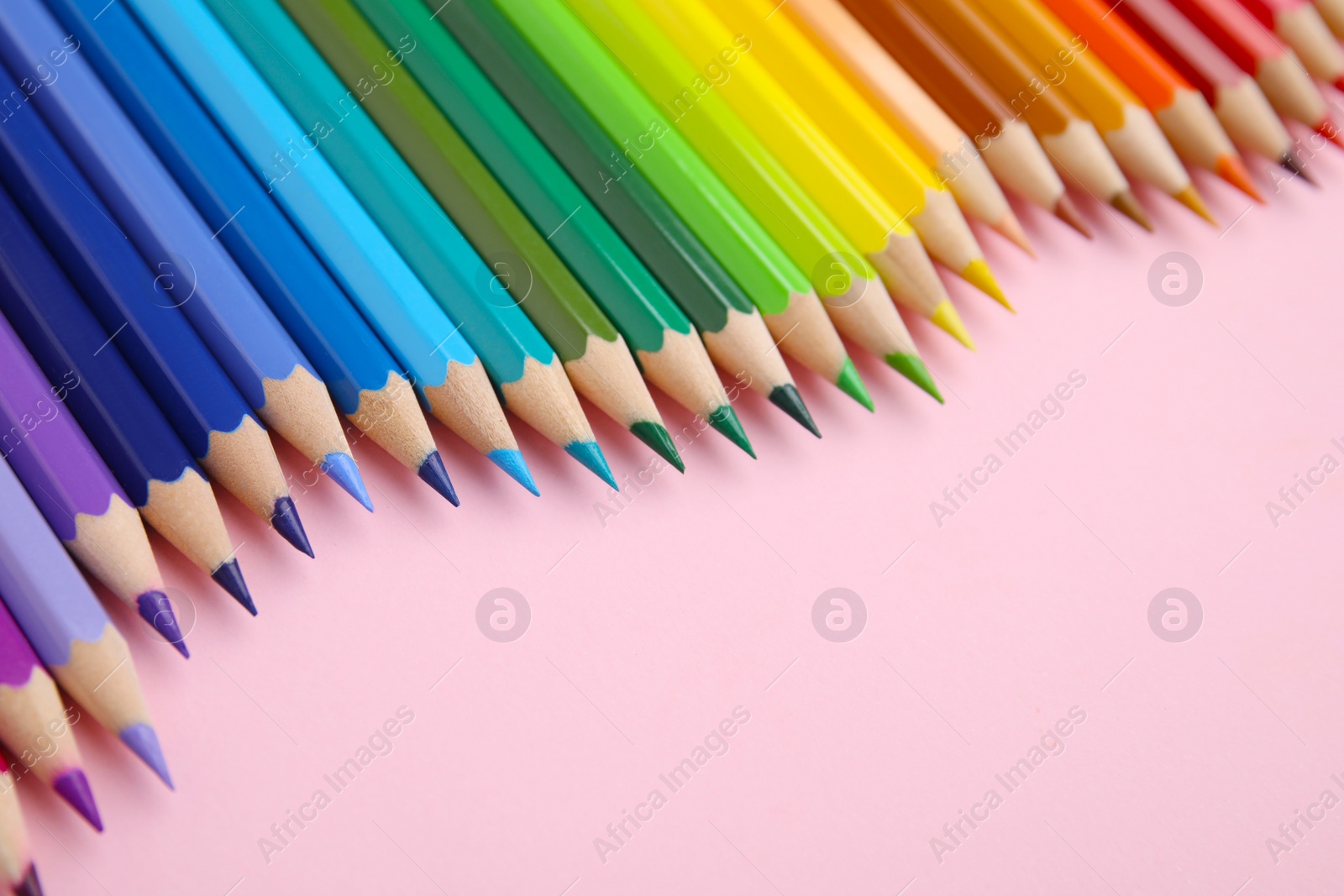 Photo of Colorful wooden pencils on pink background, closeup. Space for text