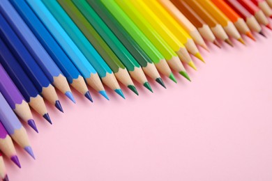 Photo of Colorful wooden pencils on pink background, closeup. Space for text