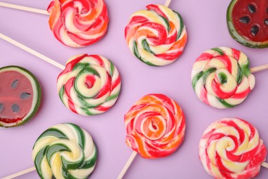 Photo of Many different lollipops on violet background, flat lay