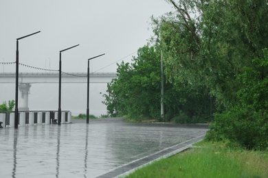 Photo of Empty city embankment under heavy rain on spring day