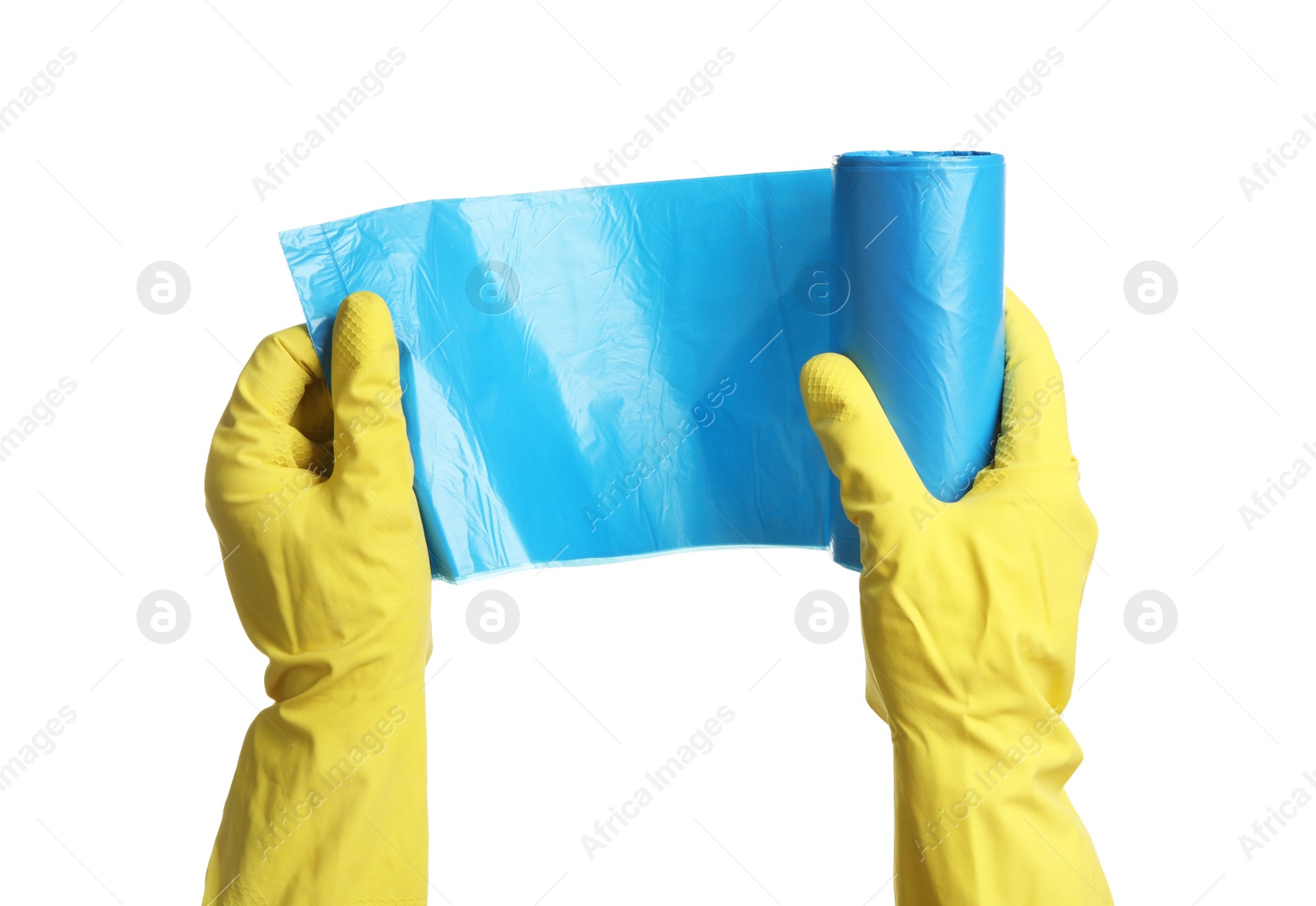 Photo of Person in rubber gloves holding roll of turquoise garbage bags on white background, closeup. Cleaning supplies