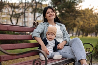 Photo of Family portrait of happy mother and her baby on bench in park