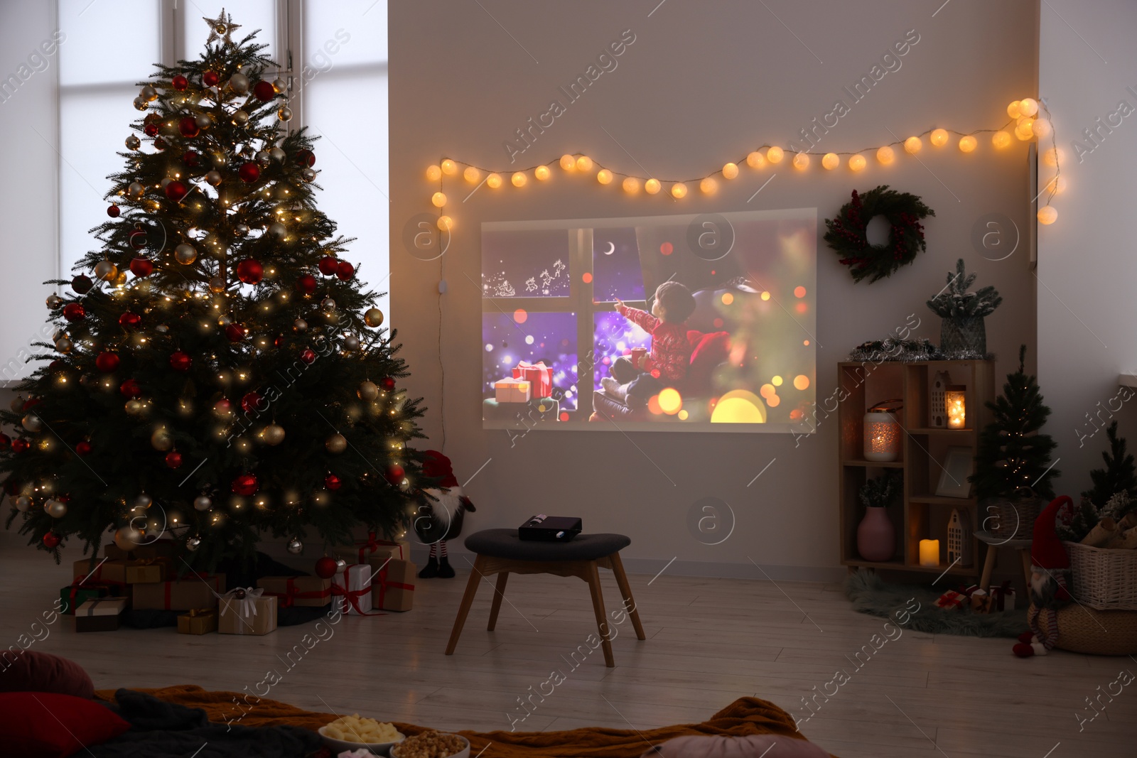 Photo of Video projector, Christmas tree, snacks, gifts and decorations in room