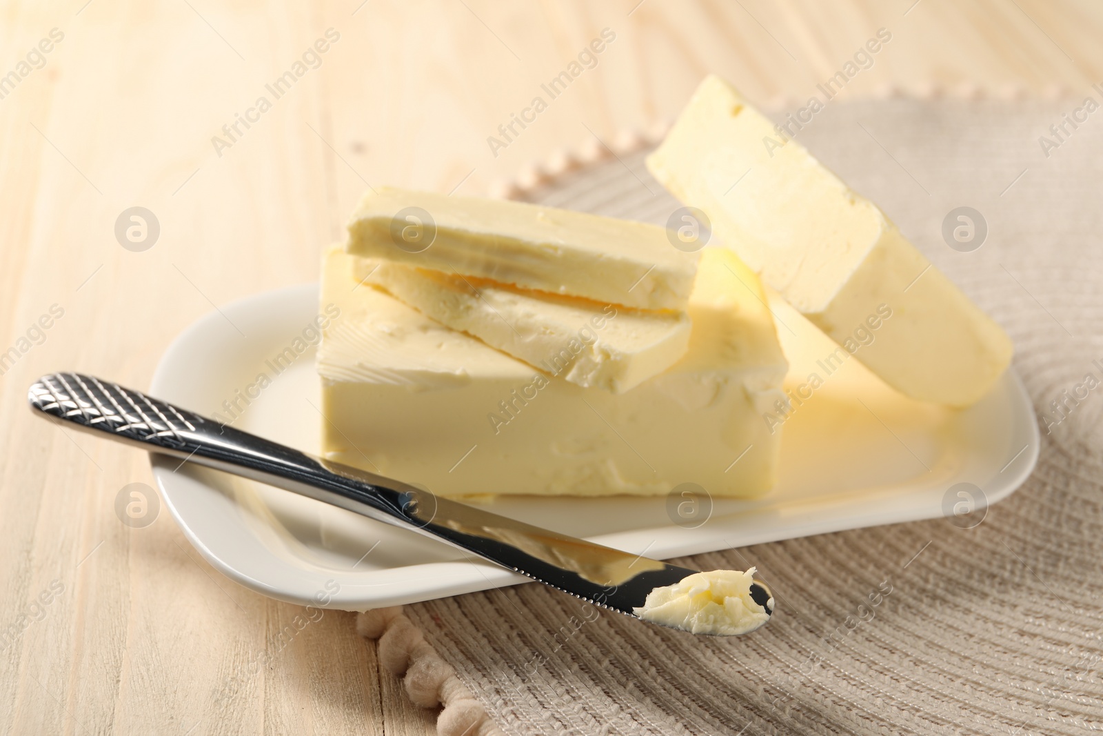 Photo of Tasty butter and knife on wooden table