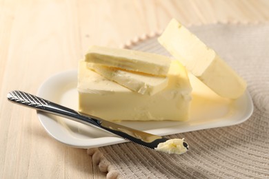 Tasty butter and knife on wooden table