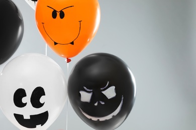 Photo of Spooky balloons for Halloween party on light grey background, space for text