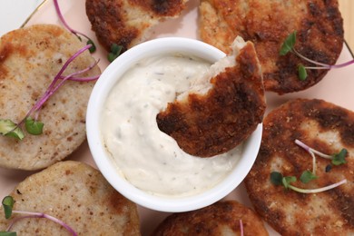 Delicious vegan cutlets and sauce on plate, top view