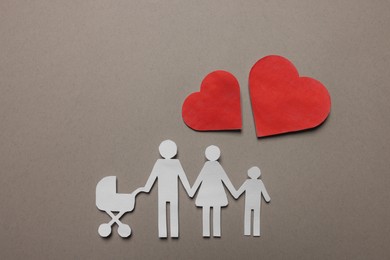Photo of Paper family figures and red hearts on light grey background, flat lay. Insurance concept