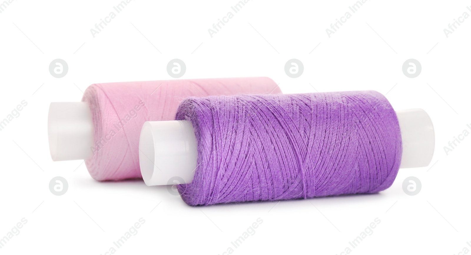 Photo of Different colorful sewing threads on white background