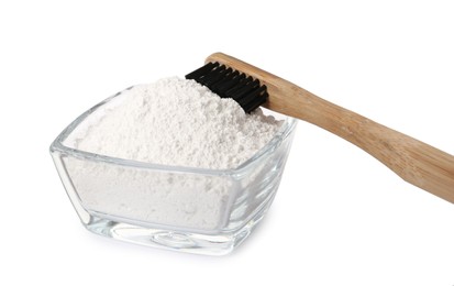 Glass bowl of tooth powder and brush on white background