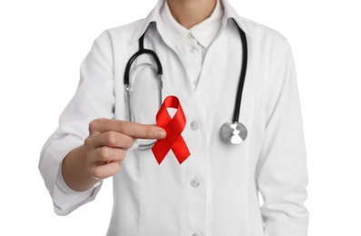 Photo of Doctor holding red ribbon on white background, closeup. AIDS awareness month