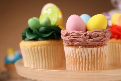 Photo of Tasty cupcakes with Easter decor on stand, closeup