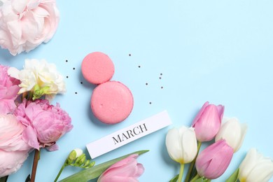 Photo of International Women's day. 8th of March made with delicious macarons and beautiful flowers on light blue background, flat lay. Space for text