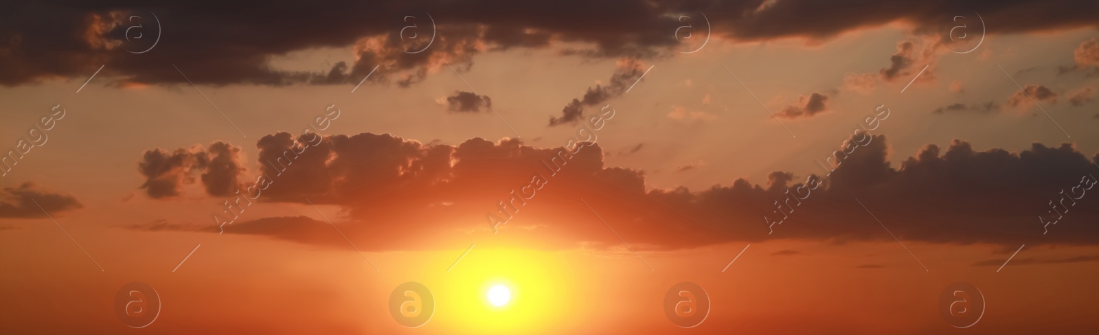 Image of Sun shining on beautiful cloudy sky at sunset, banner design