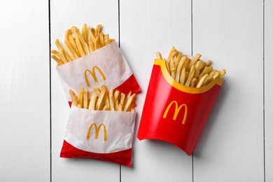 Photo of MYKOLAIV, UKRAINE - AUGUST 12, 2021: Small and big portions of McDonald's French fries on white wooden table, flat lay